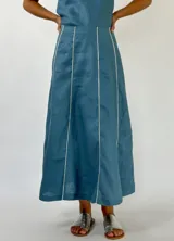 Pollera larga color beige con paneles verticales y ribetes blancos.