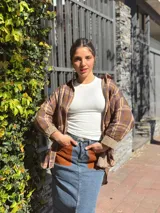 Falda midi de denim con elastano, corte recto y tajo frontal. Presenta bolsillos delanteros de cuero en color tostado y diseño clásico.