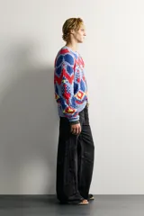 Jersey de punto tejido en hilatura de algodón, con diseño de patrones geométricos en colores celeste, azul, rojo y amarillo. Presenta cuello redondo, manga larga y acabados en rib.