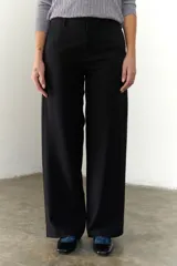 Pantalón marrón de corte recto y pierna ancha, con cintura alta, bolsillos laterales y cierre.