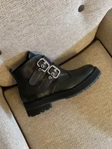 Botas negras de cuero vacuno con hebillas plateadas y suela track.