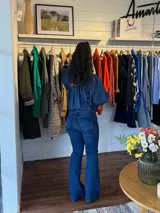 Jean de tiro alto en denim azul, con corte ajustado en la parte superior y botamanga ligeramente acampanada.