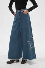Pantalon de jean negro de corte ancho y tiro alto, con detalle de estrella bordada en la pierna y ruedo deshilachado.