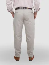 Pantalón de vestir negro, de corte recto, con bolsillos laterales y traseros. Se ajusta a la cintura con cinturón de cuero marrón.
