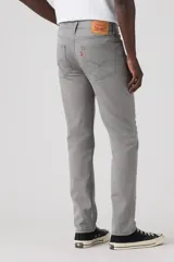 Pantalón de corte slim fit confeccionado en sarga de algodón con elastano, color gris. Presenta diseño clásico de cinco bolsillos, cierre de botón y cremallera, y costuras reforzadas.