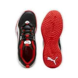 Championes deportivos Puma modelo Playmaker 2023, con diseño en color negro, blanco y rojo. Presentan una estructura de malla transpirable con refuerzos sintéticos, entresuela blanca amortiguada y suela de goma roja con textura antideslizante.