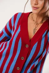 Saco oversize tejido con diseño de rayas verticales en colores rojo y azul. Presenta escote en V, cierre frontal con botones y puños y ruedo acanalados.