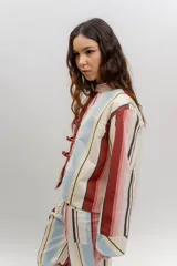 Chaqueta liviana de jean celeste con cuello mao, cierre frontal con alamares y detalle de bordados florales.
