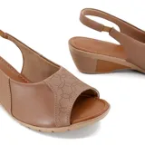 Sandalia de cuero negra con puntera abierta y talón cubierto. Cuenta con una tira trasera con hebilla y una plataforma de goma color beige con tecnología Care Juanetes.