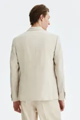 Blazer de botonadura sencilla confeccionado en una mezcla de lino y lyocell. Presenta solapas de pico, cierre frontal de dos botones, bolsillos delanteros con solapa, bolsillo superior y botones decorativos en los puños. Incluye abertura doble en la parte posterior y forro interior.