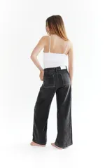 Pantalón de jean negro con costuras blancas y corte amplio.