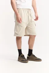 Bermuda cargo de algodón sin frisa color beige, con cintura elastizada, cordón ajustable y amplios bolsillos laterales con solapa.