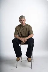 Remerón de jersey pesado color verde oliva, con cuello redondo y manga corta. Presenta un estampado sutil en el pecho y un estampado más grande en la espalda.