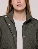 Campera capitoneada verde militar de la línea Weatherproof, con diseño a rombos, cuello alto mao, cierre frontal con cremallera y botones a presión dorados, bolsillos frontales con solapa y trabas de ajuste en la cintura.
