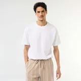 Camiseta blanca de manga corta, corte oversize y cuello redondo.