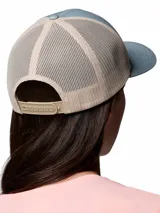 Gorra tipo trucker Columbia de color celeste con malla trasera en tono beige. Cuenta con un parche frontal bordado con diseño de montañas y el logo de la marca.