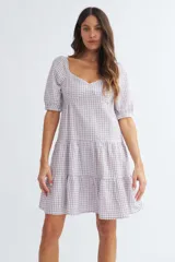 Vestido corto de algodón con estampado de cuadros vichy en color lila y blanco, escote corazón, mangas cortas abullonadas y falda escalonada con volantes.