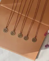 Collar de cadena fina con dije circular de acero quirúrgico que presenta el símbolo de un signo zodiacal calado.