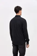 Camisa de corte regular fit confeccionada en algodón, con cuello solapa clásico, cierre frontal con botones y dos bolsillos frontales en el pecho.