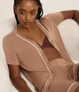 Conjunto de pijama corto color marrón, compuesto por una blusa de manga corta con botones y un short con cintura elástica y detalle de ribete blanco en cuello, ruedo y mangas.