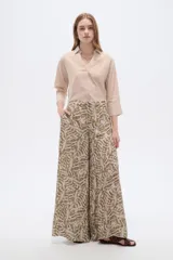 Pantalón de poliéster ancho con estampado botánico en tonos verde militar y beige, de tiro alto.