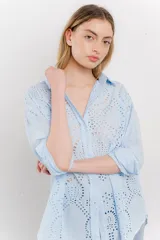 Camisa celeste de algodón liviano con bordado calado tipo broderie, manga larga con puño angosto y botones al frente.