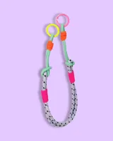 Correa para bolso de diseño moderno, confeccionada con cuerda técnica gris con patrón de puntos negros, acentuada con detalles en colores neón como verde, naranja y fucsia, y rematada con dos argollas metálicas en los extremos.