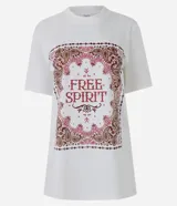 Remera blanca de algodón con cuello redondo, manga corta y diseño alargado. Presenta un estampado frontal rectangular con marco de estilo paisley y la inscripción "Free Spirit" en tonos bordó y rosado.