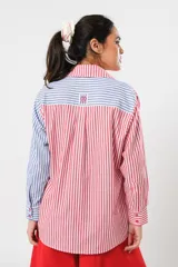 Camisa a rayas rojas y blancas en un lado y azules y blancas en el otro, con corte en A y abertura central con botonadura doble.