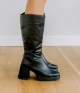 Bota de cuero color marrón, con taco de madera forrado en cuero, punta cuadrada y cierre lateral.