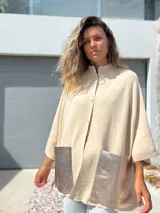 Saco tejido de punto en color crudo, con diseño holgado, mangas tres cuartos y bolsillos frontales grandes confeccionados en cuero metalizado plateado.