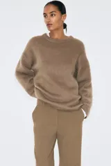 Pantalón sastrero color marrón, de corte recto y tiro medio, con bolsillos laterales y pinzas delanteras.