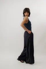 Chaleco de denim azul con cuello en V, cierre frontal con botones metálicos y pespuntes en contraste.