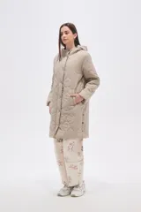 Campera acolchada de largo medio en color negro, con diseño de costuras onduladas, cierre frontal con botones a presión y bolsillos laterales.