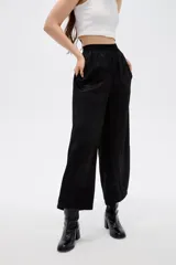 Pantalón ancho negro de poliéster, con tiro alto y cintura elástica.