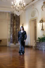 Pantalón de lino color negro, de corte recto y holgado, con detalle de volados en el ruedo y cierre frontal con botón de nácar.