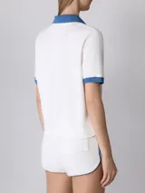 Remera polo deportiva Prince de rizo blanca con cuello y mangas en azul. Fabricada en Portugal con 100% algodón, mangas y dobladillo inferior acanalados, cuello abierto y corte cuadrado.