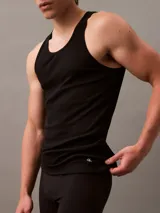 Pack de tres remeras de tirantes Calvin Klein color negro, confeccionadas en algodón puro. Presentan cuello abierto, diseño sin mangas y logo monograma bordado en el dobladillo.