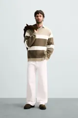 Jersey de punto de hombre, manga larga y cuello redondo, con diseño de bloques de color horizontales en tonos beige, blanco roto y verde oliva/marrón.