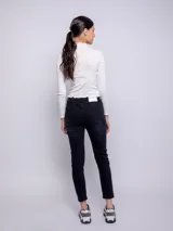 Pantalón de jean chupín color azul medio, con cinco bolsillos, presillas, botón y cierre metálico.