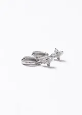 Aros tipo argolla con dije colgante en forma de flor compuesto por zirconias brillantes. Fabricados en plata 925.