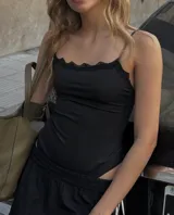 Body negro de tirantes finos con escote adornado con encaje festoneado.