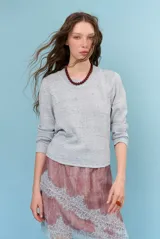 Sweater de punto celeste con efecto melange, cuello redondo y mangas largas.