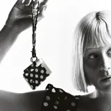 Billetera elástica de tejido resistente, color negro con estampado de lunares blancos, ideal para tarjetas y efectivo. Cuenta con argolla metálica lateral para llavero.