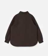Camisa de corte largo tipo shacket, confeccionada en polivelour color marrón. Presenta cuello camisero, cierre frontal con botones, hombros caídos, mangas largas y dos bolsillos frontales aplicados con solapa.