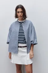 Short pollera de tiro alto confeccionado en algodón, con diseño cruzado en el delantero que simula una falda, cierre lateral invisible y bolsillos traseros.