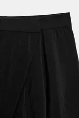 Pantalón de tiro alto con diseño cruzado tipo pareo en el frente, pernera ancha y caída fluida.