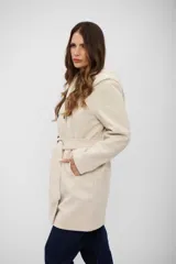 Tapado de paño color beige con capucha, cierre frontal cruzado con botones y lazo ajustable en la cintura.