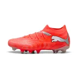 Championes de fútbol Puma Future Match FG/AG, color naranja vibrante con detalles en plateado. Presentan un diseño de caña media tejida y suela con tapones mixtos para césped natural y artificial.
