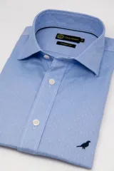 Camisa celeste de manga larga Club House, modelo Lucky de corte clásico, con patrón de pequeños puntos blancos, cuello corto y detalle de bordado de pájaro oscuro en la parte inferior.